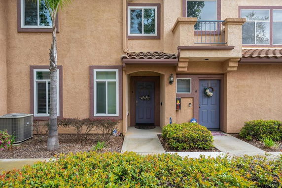 Front view of a two-story house with two entrance doors and decorative wreaths.