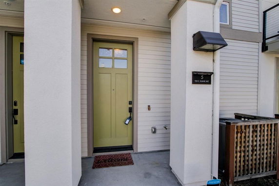 Front view of a house entrance with a green door and porch light.
