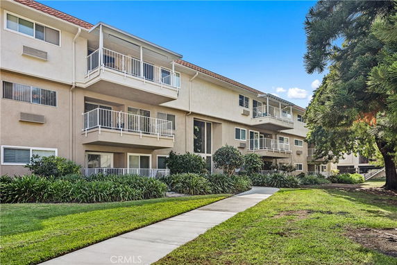 Front view of a three-story apartment building with balconies.
