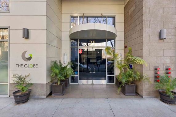 Entrance of a building named 'The Globe' with glass doors and potted plants.