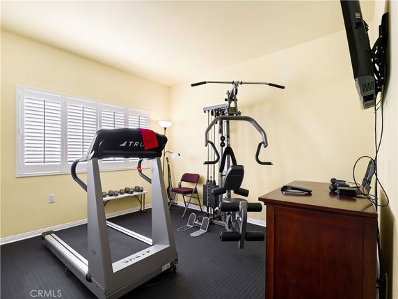 Indoor gym area with exercise equipment and TV.