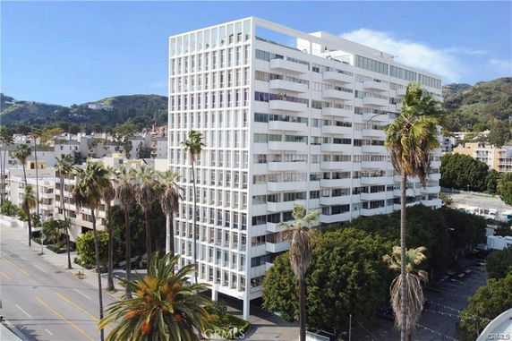 Front view of a multi-story apartment building with outdoor balconies.