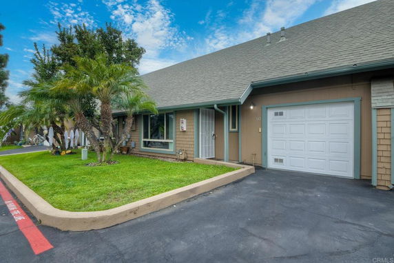 Front view of a house with a single garage and sloped roof.