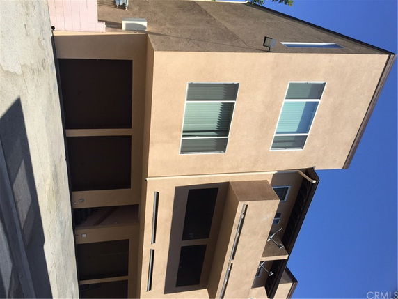 Front view of a multi-story building with large windows and balconies.