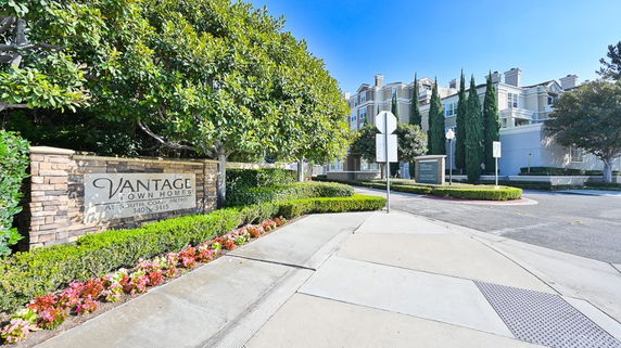Front view of a multi-story building with signage reading 'Vantage Townhomes'.