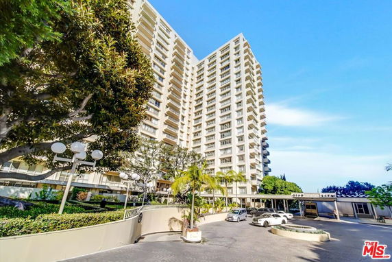 Front view of a high-rise residential building with multiple balconies.