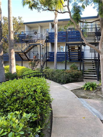 Front view of a two-story building with external staircases and balconies.