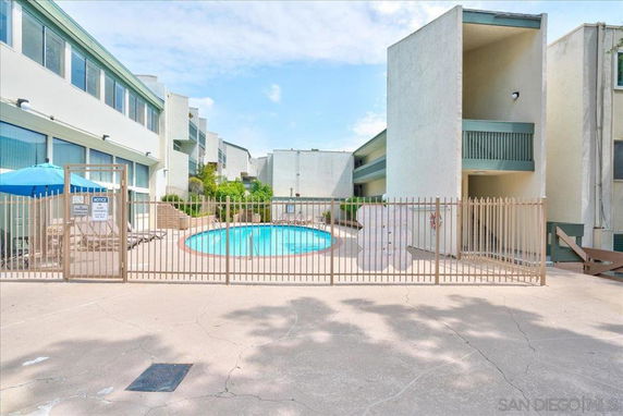 Outdoor view of a swimming pool area with surrounding buildings.