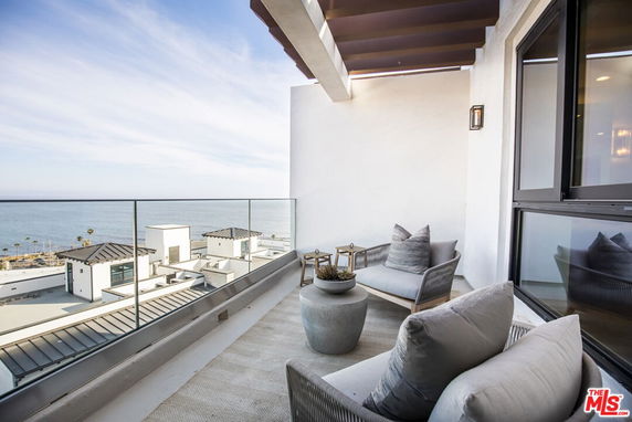 Terrace with ocean view from a modern building's balcony.