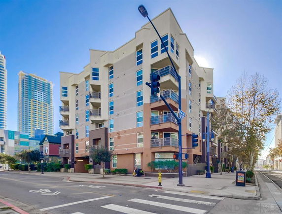 Front view of a multi-story apartment building on a street corner.