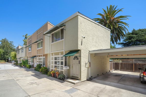 Front view of a row of two-story townhouses with attached carports.