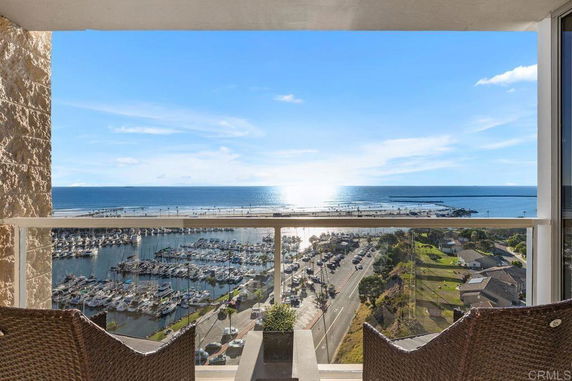 Panoramic view of the ocean and marina from a building balcony.