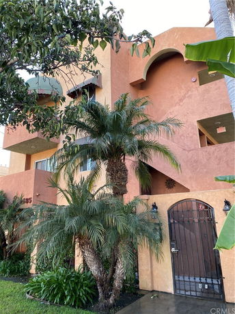Front view of a multi-story building with arches and gated entrance.