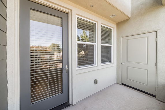 Exterior view of a building corner with a door and windows.