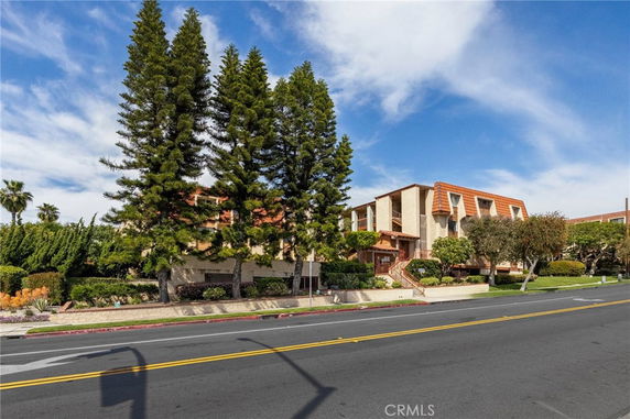 Front view of a multi-story apartment building with trees.