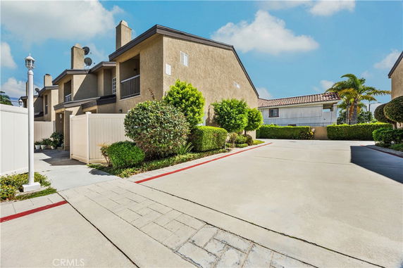 Front view of a two-story building with a beige exterior and a paved driveway.