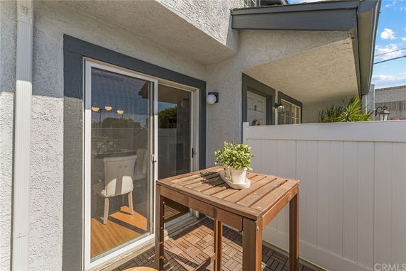 Exterior view of a house with a sliding glass door opening to a small fenced patio area.