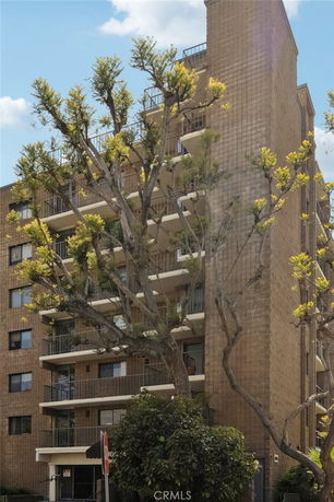 Front view of a multi-story apartment building with balconies.