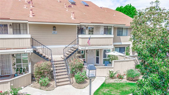 Front view of a two-story residential building with a central staircase and multiple balconies.