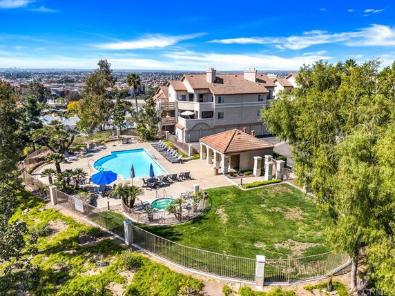 Aerial view of a swimming pool area adjacent to a residential building.