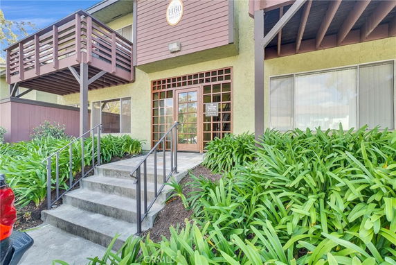 Front view of a building entrance with a wooden balcony above.