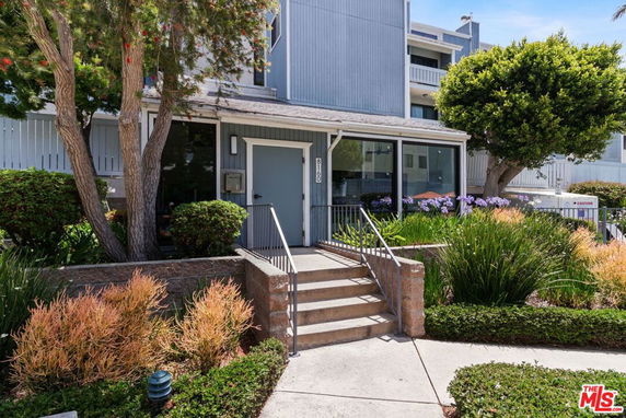Front view of a residential building with steps leading to the entrance.