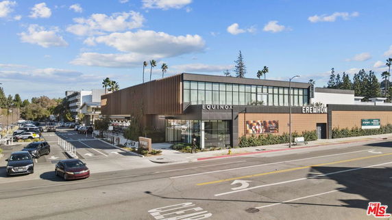 Front view of a modern commercial building with glass windows and wooden paneling.