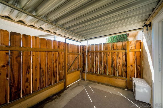 Covered outdoor parking area with wooden fence.