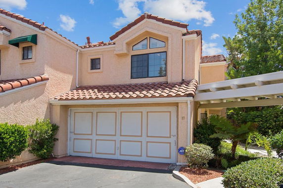 Front view of a two-story house with a tiled roof and attached garage.