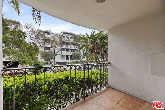 View from a balcony showing a modern multi-story residential building nearby.
