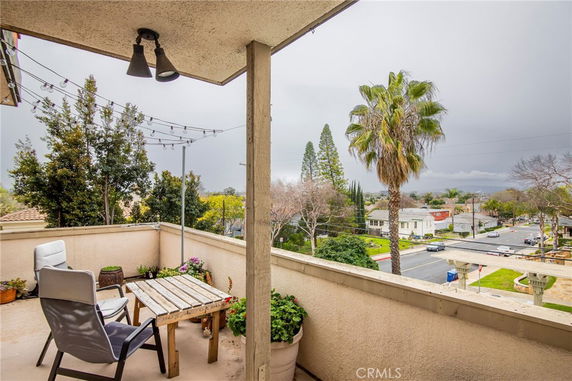Balcony view showing surrounding neighborhood with trees and houses.