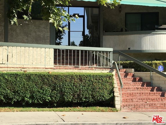 Front view of a building entrance with brick steps and railings