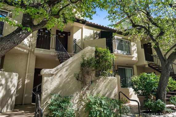 Front view of a multi-story building with balconies and exterior stairs.