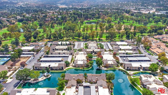 Panoramic view of residential complex with waterways and surrounding greenery.