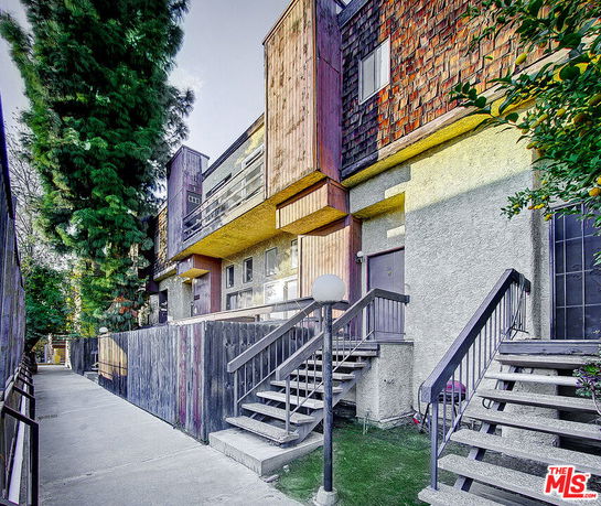Front view of a multi-story building with wooden accents and staircases.