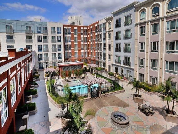 Outdoor view of a multi-story residential building with a central swimming pool area.
