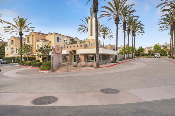Front view of a multi-story residential complex with palm trees.