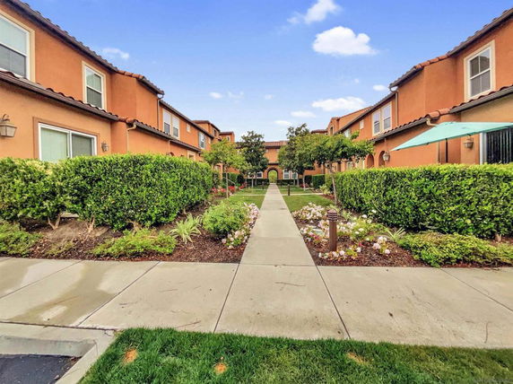 Front view of a two-story building with landscaped pathway.