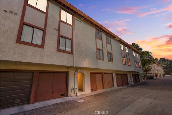 Front view of a multi-story building with multiple garage doors on the ground level.
