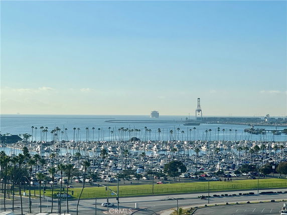 Panoramic view of a marina with numerous boats and the ocean in the background.