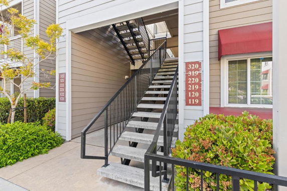 Front view of a multi-story building with an exterior staircase.