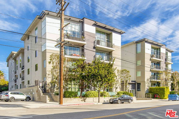 Front view of a multi-story apartment building with balconies.