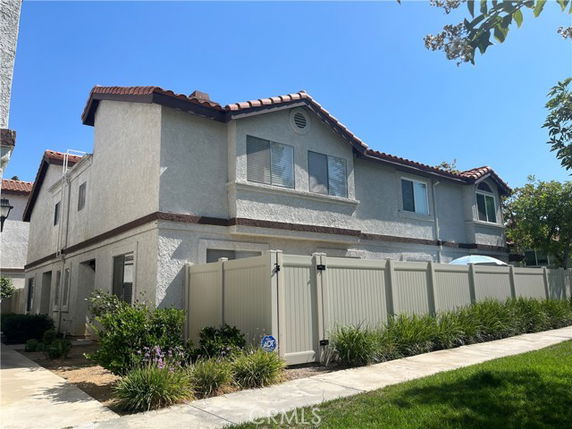 Front view of a two-story house with a fenced yard.
