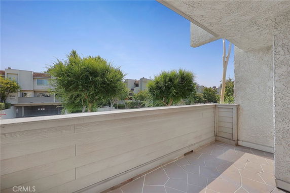 View from a balcony overlooking nearby residential buildings and trees.