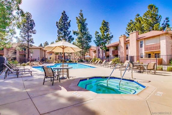 Outdoor swimming pool area with lounge chairs and umbrellas.