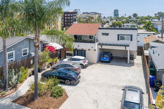 Outdoor parking area in front of a two-story building.