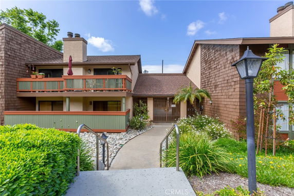 Front view of a two-story building with wooden balconies and shingle siding.