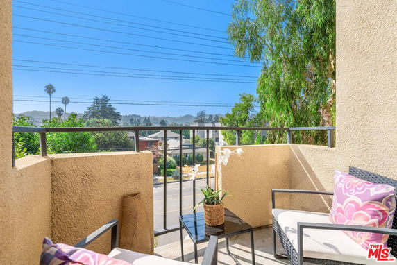 View of surrounding areas from a balcony with seating and railings.