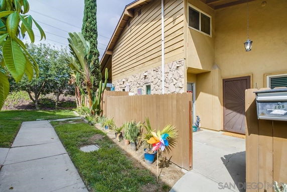 Front view of a house with a wooden fence and a small garden.