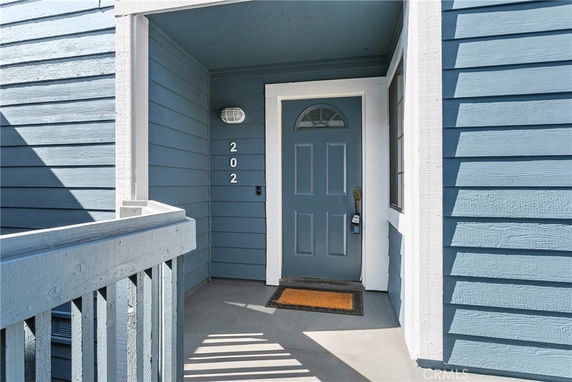 Front view of a house entrance with a blue door and matching siding.